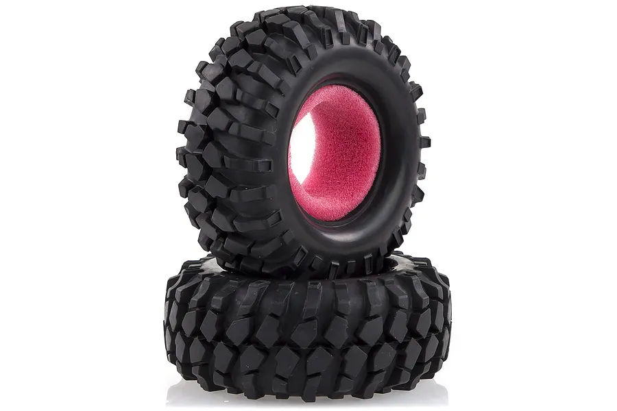 Two black rubber RC rock crawler tyres stacked on top of each other, featuring aggressive tread patterns and bright pink foam inserts.