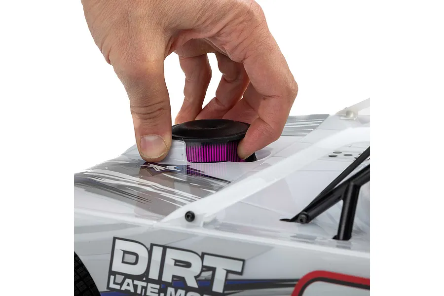 A person's hand installing a black and purple air filter cover onto the white body of a Losi 22S Dirt Late Model RC car.
