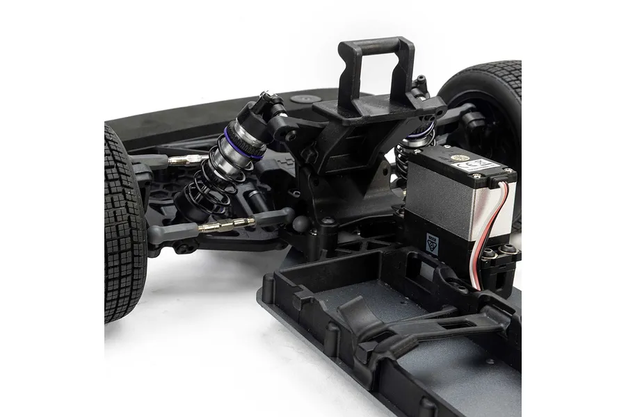 Close-up of the front chassis and suspension of a Losi 22S RC car showing the steering servo, shock absorbers, and front wheels.