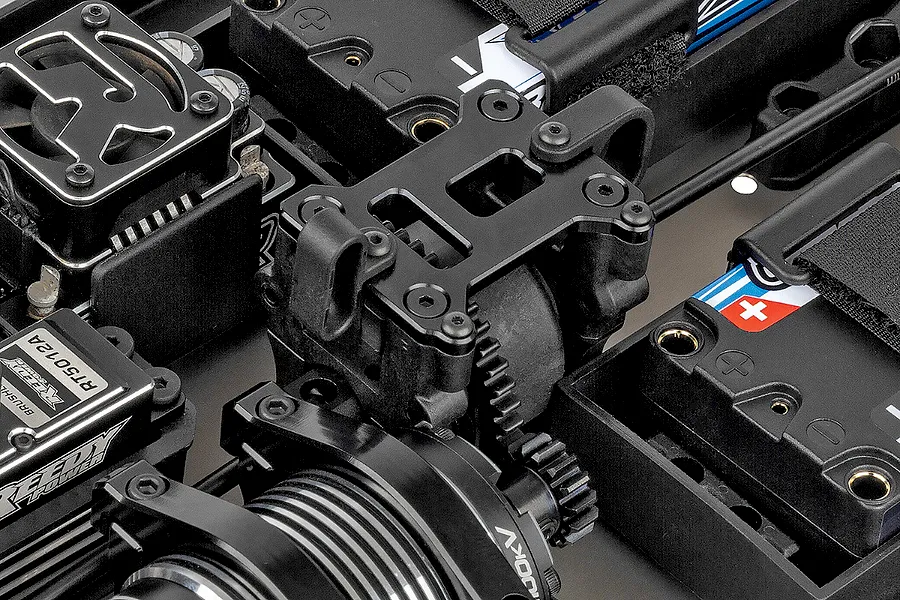 Close-up of the internal chassis components of a Team Associated RC8T4.2e RC truggy, showing the motor, center differential, and battery tray.