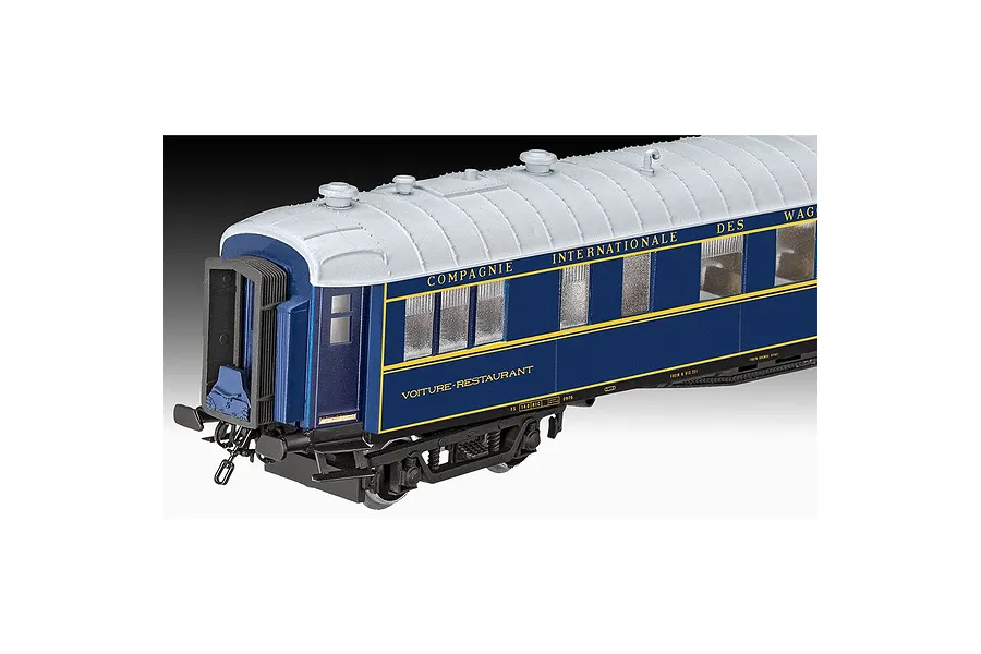 A side view of a detailed blue and white Orient Express restaurant carriage model kit against a black background.