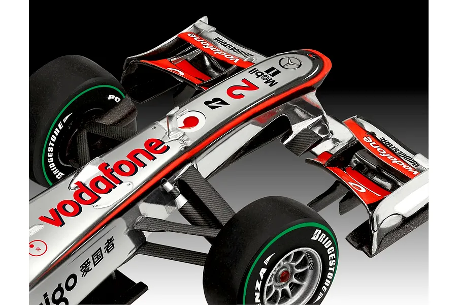 Close-up of a 1/24 scale McLaren Mercedes Formula 1 model car featuring Vodafone branding, Bridgestone tires, and detailed carbon fiber texture.