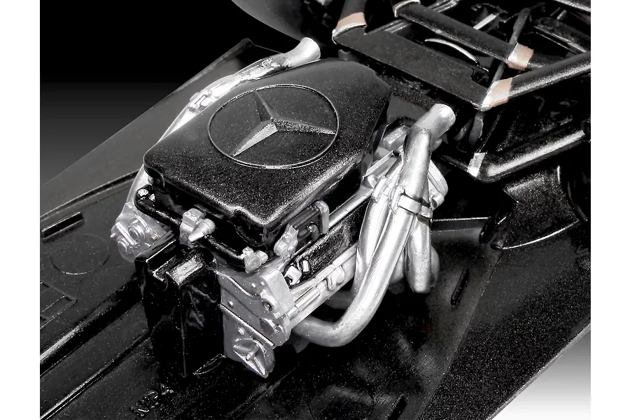 Close-up of a detailed scale model Formula 1 engine with a Mercedes-Benz logo on the black engine cover.