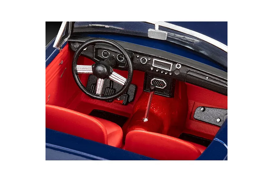 Close-up view of the detailed red interior and black dashboard of a 1/32 scale MGB Roadster model car kit.