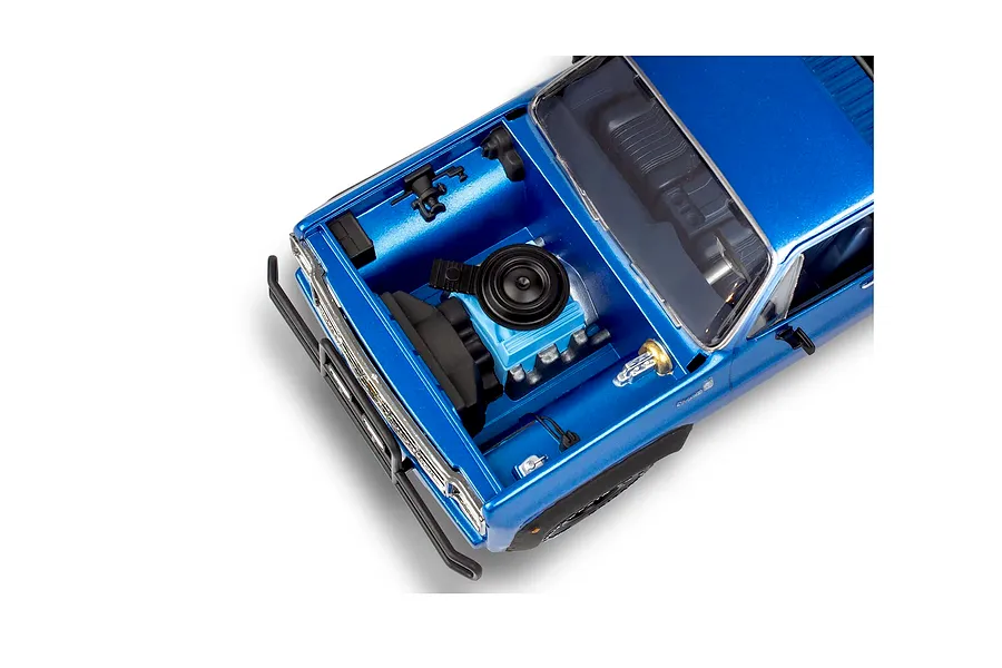 High-angle view of the engine bay of a blue 1/25 scale 1978 Chevy 4x4 pickup model kit with the hood removed.