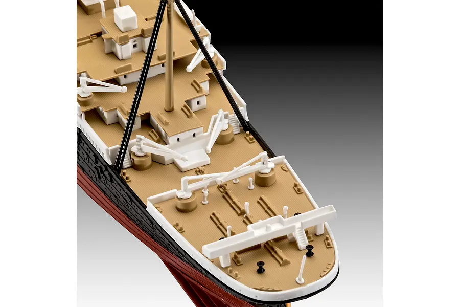 Close-up of the deck of a Revell 1/600 scale RMS Titanic model kit, showing molded plastic details like lifeboats, masts, and deck structures.