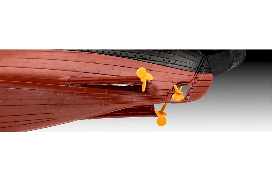 Close-up view of the stern section of a plastic model ship kit showing the red hull, black upper section, and three yellow propellers.