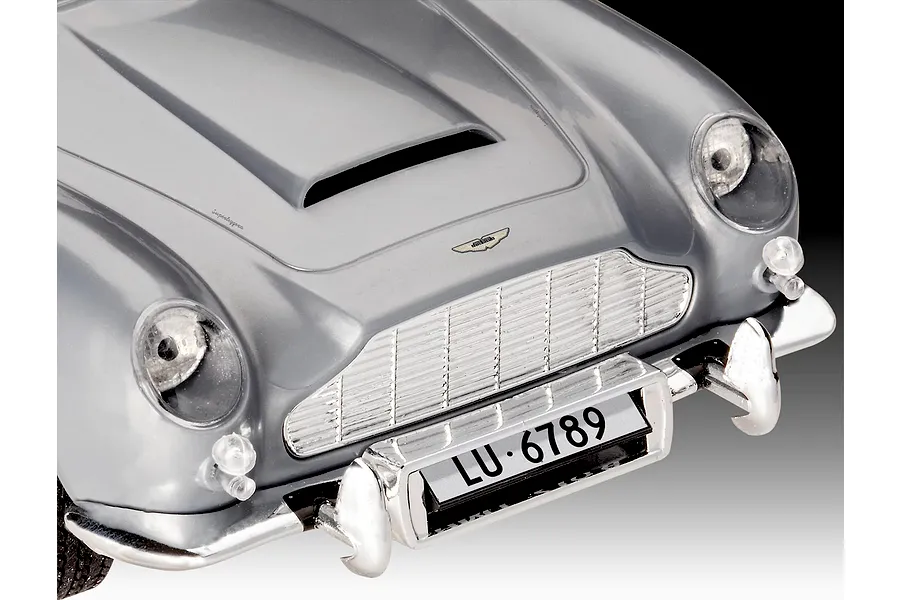 Close-up of the front hood, grille, and bumper of a silver Aston Martin DB5 model car.