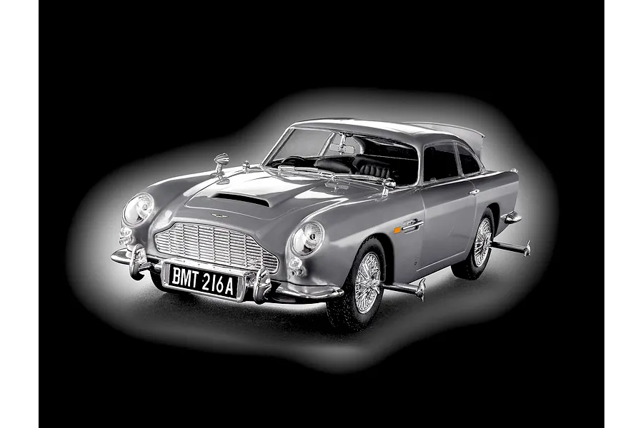 A 1/24 scale model of the James Bond Aston Martin DB5, finished in silver with wire wheels and BMT 216A license plate, set against a black background.