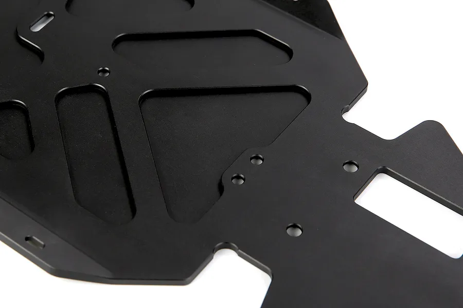 Close-up of a black anodized aluminium RC main chassis plate featuring various cutouts and mounting holes.