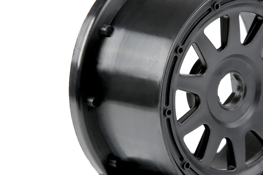 A close-up view of a black Rovan 1/5 scale RC short course rear rim against a white background.