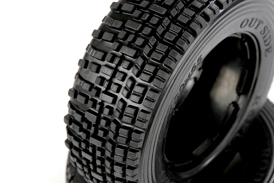 Close-up of a black Rovan 1/5 scale RC short course truck tyre with a blocky tread pattern, showing the sidewall markings against a white background.