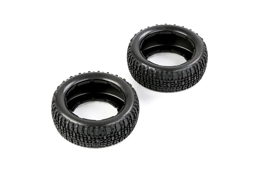 Two black rubber RC short course truck tyres with a blocky tread pattern, viewed from an angle on a white background.