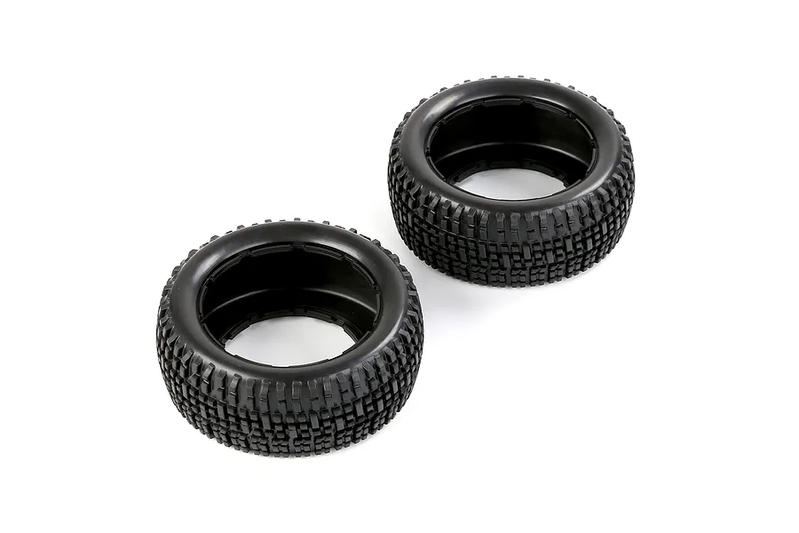 Two black rubber RC short course truck tyres with a blocky tread pattern, shown from an angled perspective against a white background.