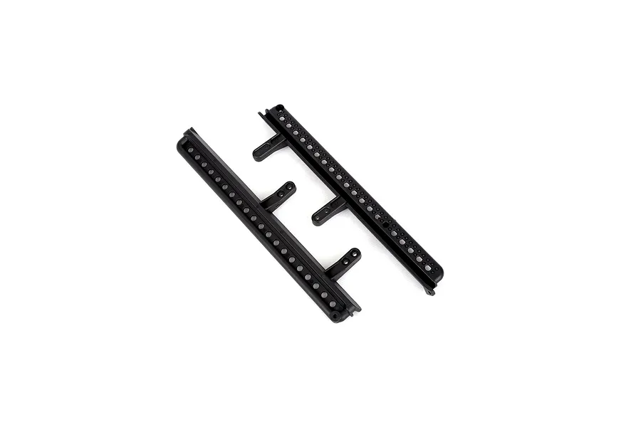 Two black plastic RGT RC crawler side steps or rock sliders with mounting tabs, isolated on a white background.