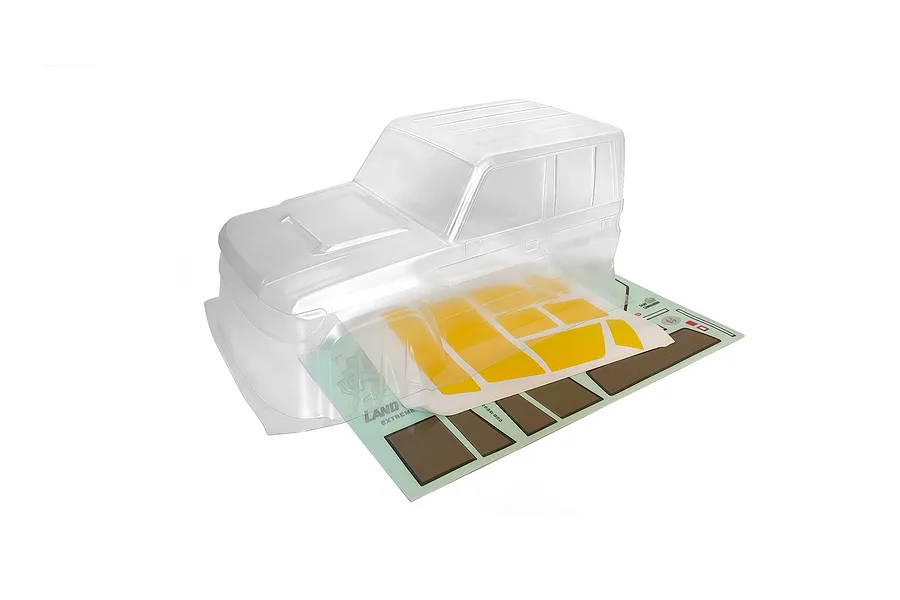 Clear unpainted RGT 1/10 scale LC79 Land Commander RC body shell cab with included decal sheet on a white background.