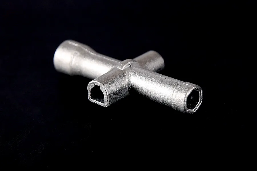 A silver-coloured metal cross wrench tool for RC vehicles, shown against a plain black background.