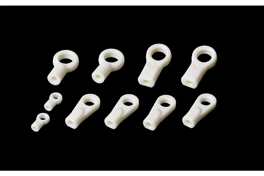 A set of ten white plastic ball ends of varying sizes arranged on a black background.
