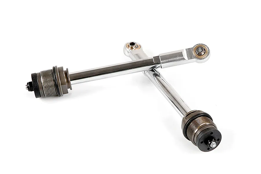 Two silver RC shock absorber shafts with threaded collars and rod ends, arranged in an X shape on a white background.