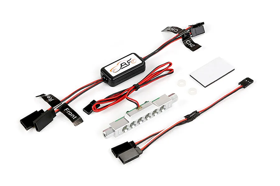 Rovan RC light controller kit featuring a control module, a silver LED light bar, wiring harnesses with labeled connectors, and adhesive mounting pads.