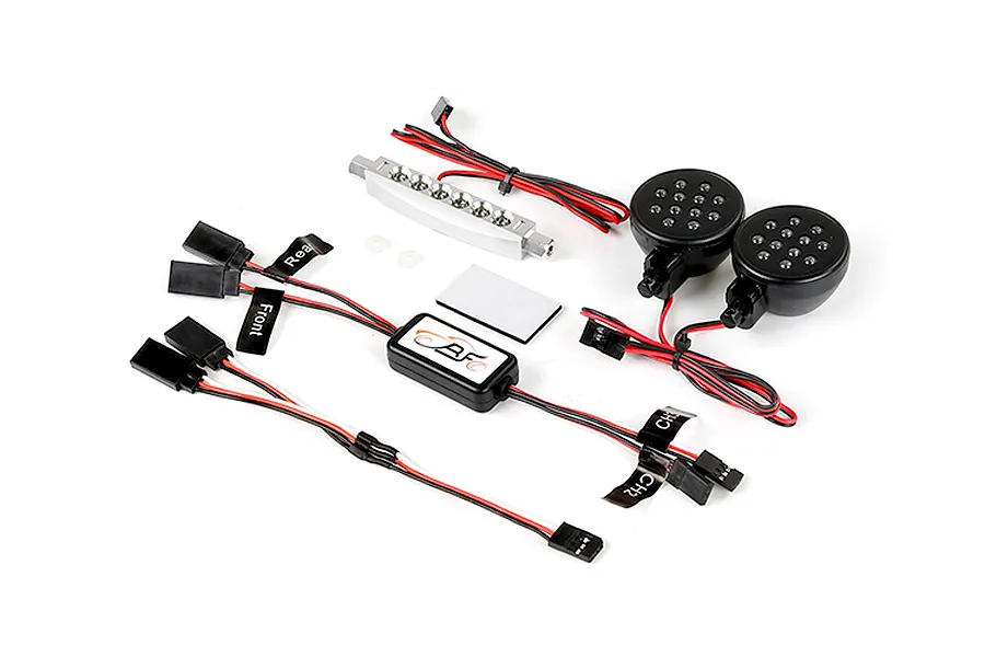 Rovan RC light controller kit including a silver LED bar, two round LED light pods, a control module, and various wiring harnesses with labels.