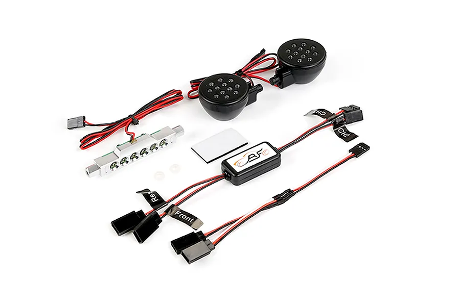 Rovan RC light controller kit including a silver LED bar, two round black LED headlight housings, a control module, and various wiring harnesses.