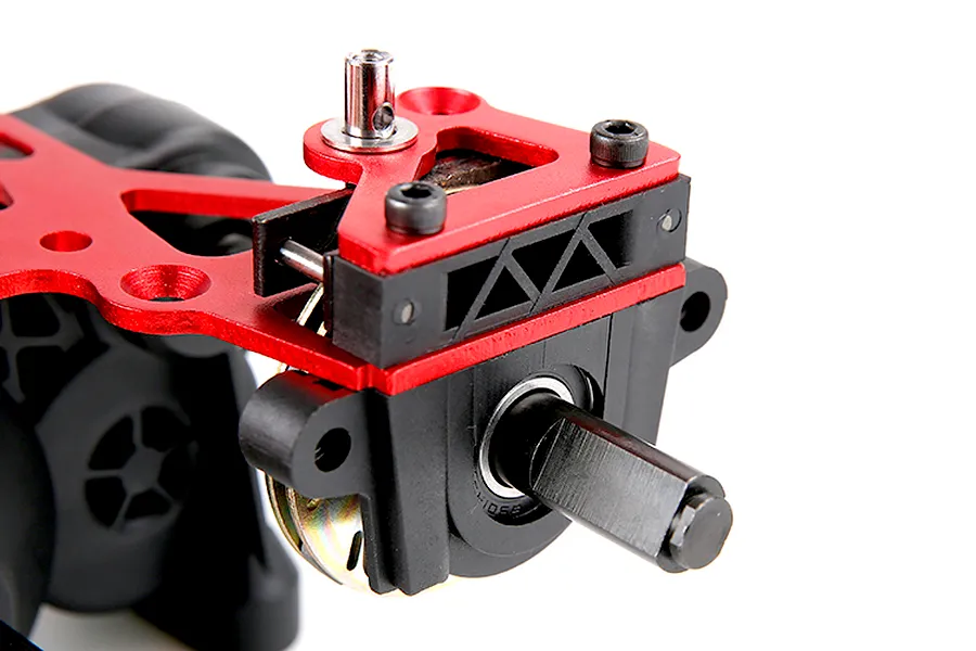 Close-up of a Rovan 1/5 scale RC Baja transmission assembly featuring red anodized aluminum plates and black plastic housing components.
