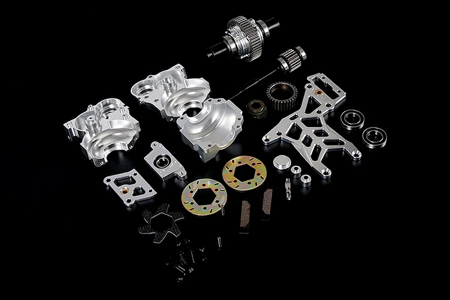 A Rovan 1/5 scale Baja silver aluminium gear differential transmission assembly kit laid out on a black background.