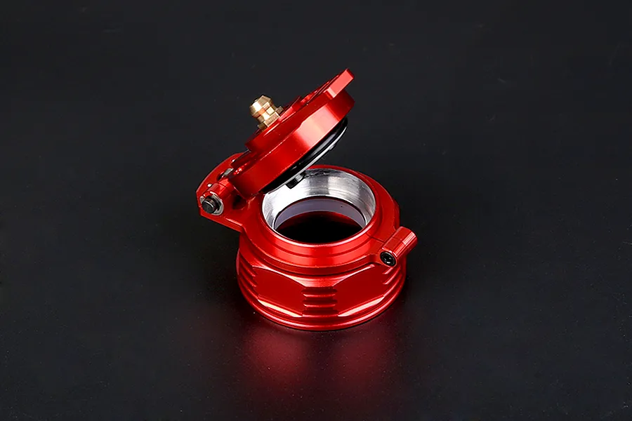 A red anodized aluminium fuel tank cap for RC cars, shown in an open position against a dark background.