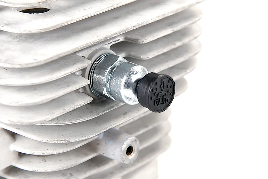 Close-up of a pressure reducing valve installed on a finned metal RC engine cylinder head.