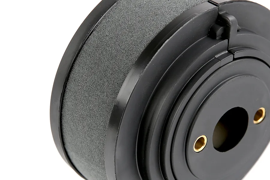 A close-up view of a black foam RC engine air filter with a plastic housing and two brass mounting eyelets.