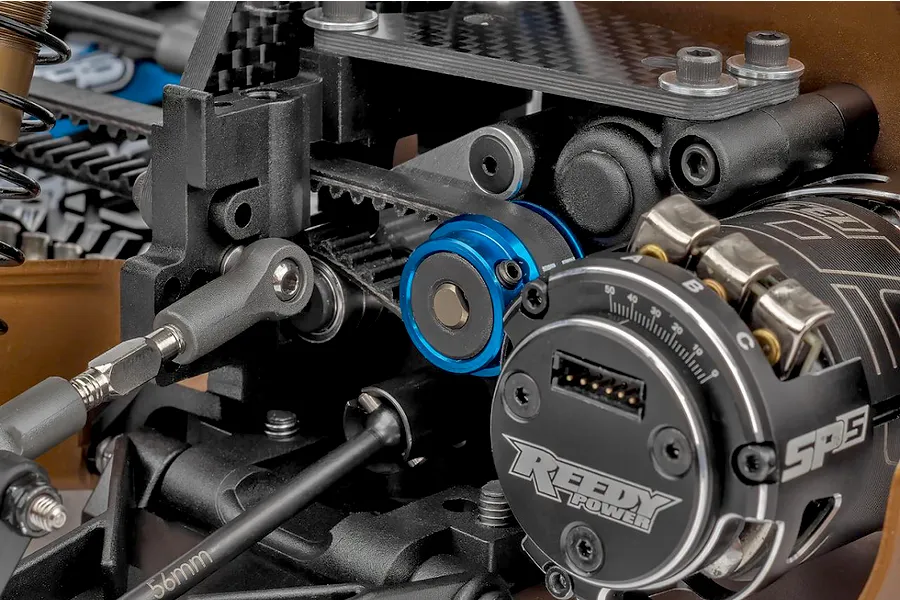Close-up of the internal components, carbon fiber chassis deck, belt drive, and Reedy Power electric motor inside a 1/10 scale RC buggy.