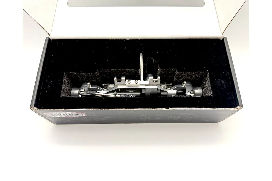 Reefs RC aluminium front portal axle set in silver, nestled inside its protective black foam packaging box.