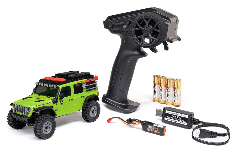 Axial SCX30 green Jeep Wrangler RC rock crawler RTR with transmitter, batteries, and USB charger on a white background.