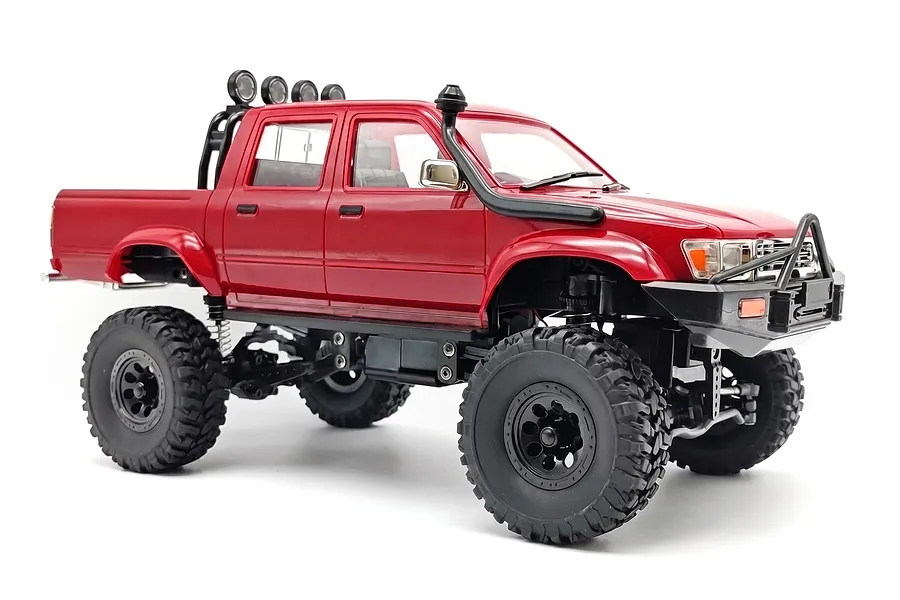 Red WPL C64-1 Hilux RC rock crawler pickup truck viewed from front right against a plain white background.