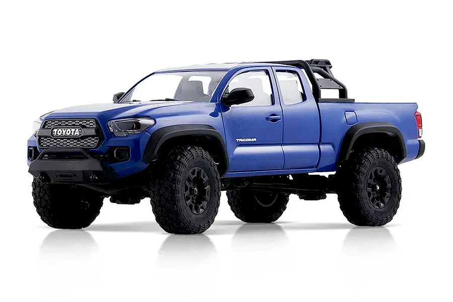 Studio product photo of a blue FMS FCX24M Toyota Tacoma RC rock crawler truck on a white background.