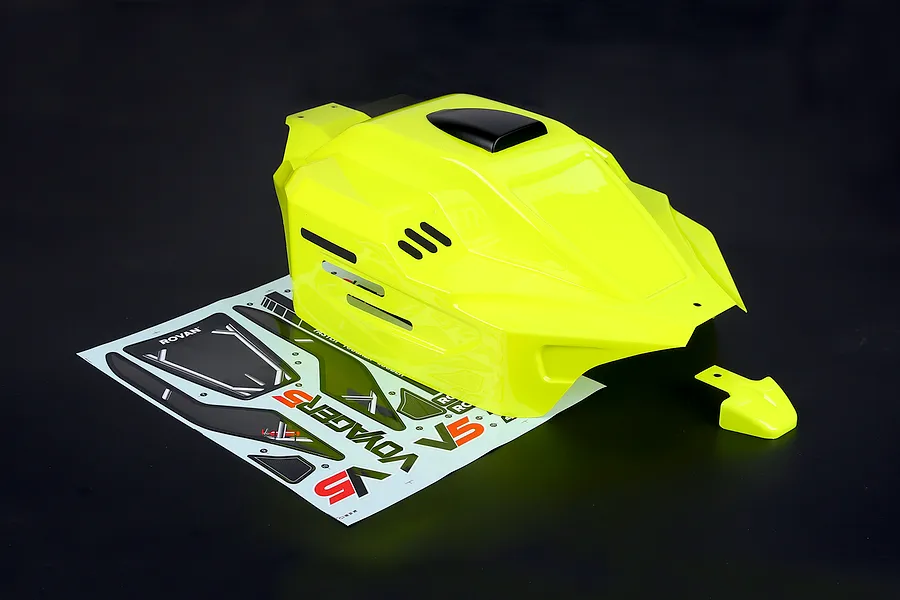 Bright yellow painted RC buggy body shell with a matching smaller piece and an unapplied decal sheet on a dark background.
