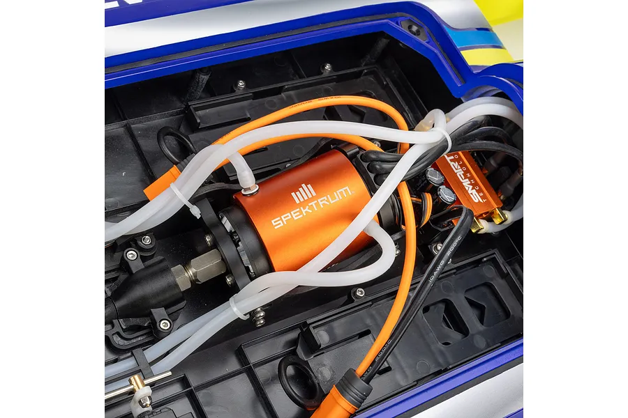 Close-up of the internal electronics compartment of the Pro Boat Miss Illinois RC boat showing the orange Spektrum motor and wiring.