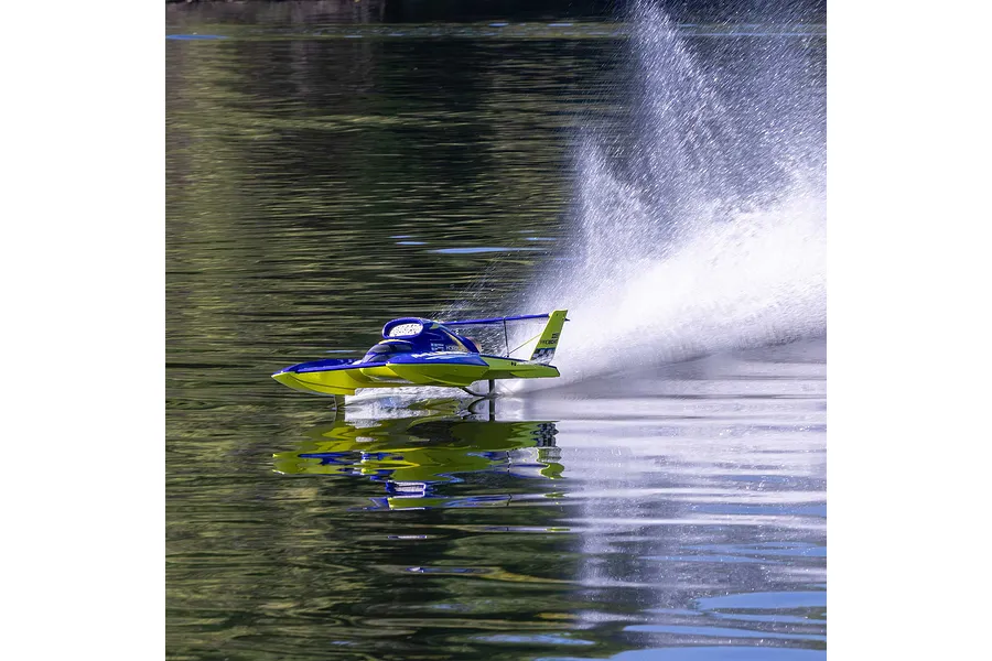 Pro Boat Miss Illinois U-34 RC boat speeding across calm water, creating a large rooster tail splash.