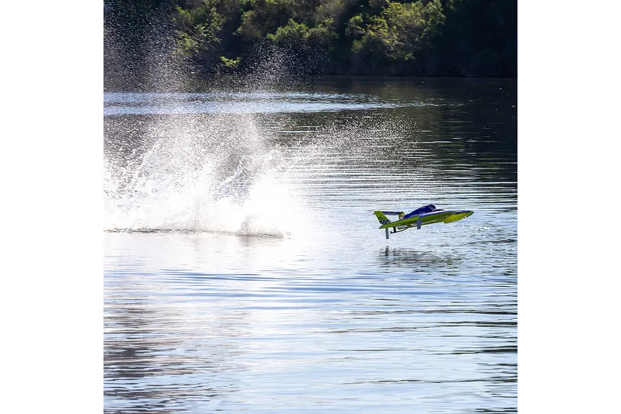 Pro Boat Miss Illinois U-34 RC boat speeding across a calm lake, creating a large splash of water.