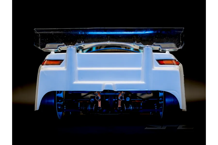 Rear view of the RC Maker SP2 EP RC Touring Car showing suspension details, white body, and clear wing.