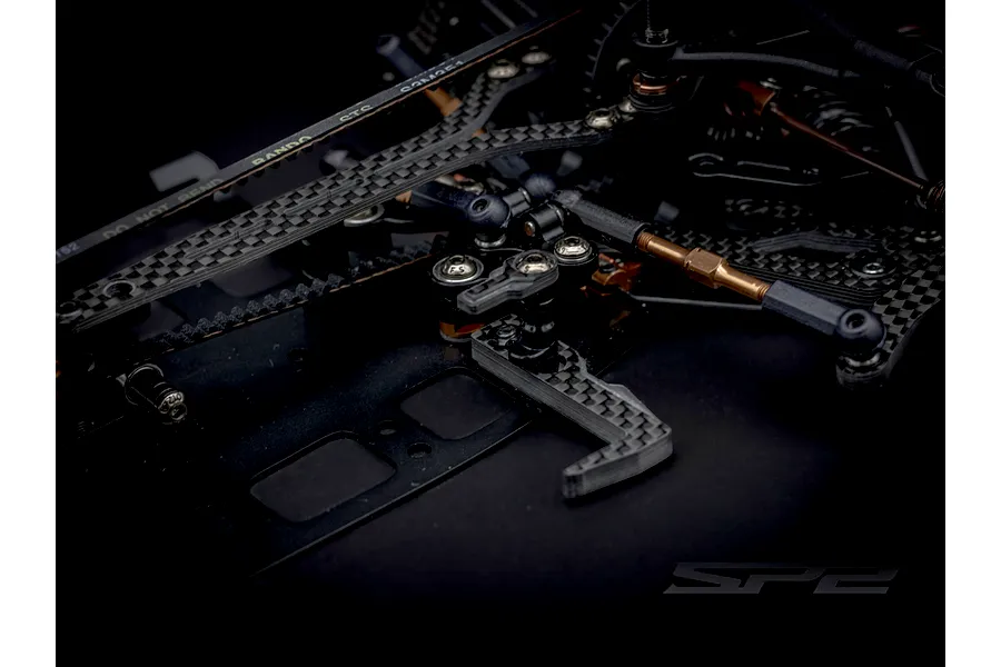 Close-up view of the carbon fibre chassis and steering assembly of the RC Maker SP2 1/10 scale touring car.