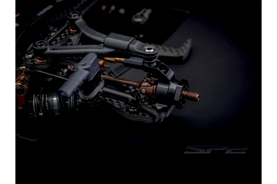 Close-up studio view of the front suspension and steering assembly of the RC Maker SP2 EP RC Touring Car.