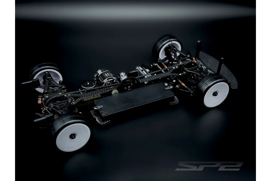 RC Maker SP2 EP 1/10 scale electric touring car chassis with carbon fibre components and white wheels.