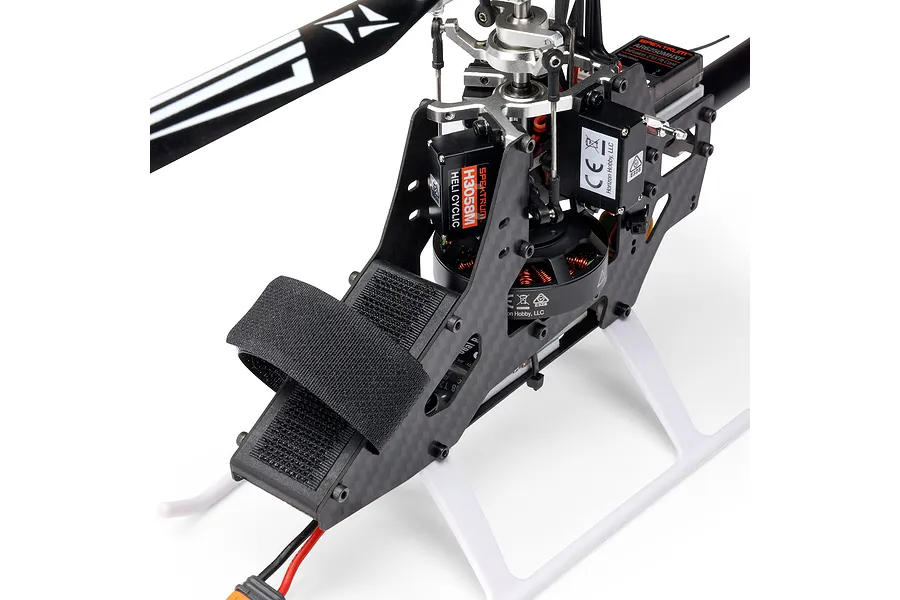 Close-up studio view of the Blade InFusion 210 RC helicopter frame, showing carbon fiber chassis, servos, motor, and rotor head details.