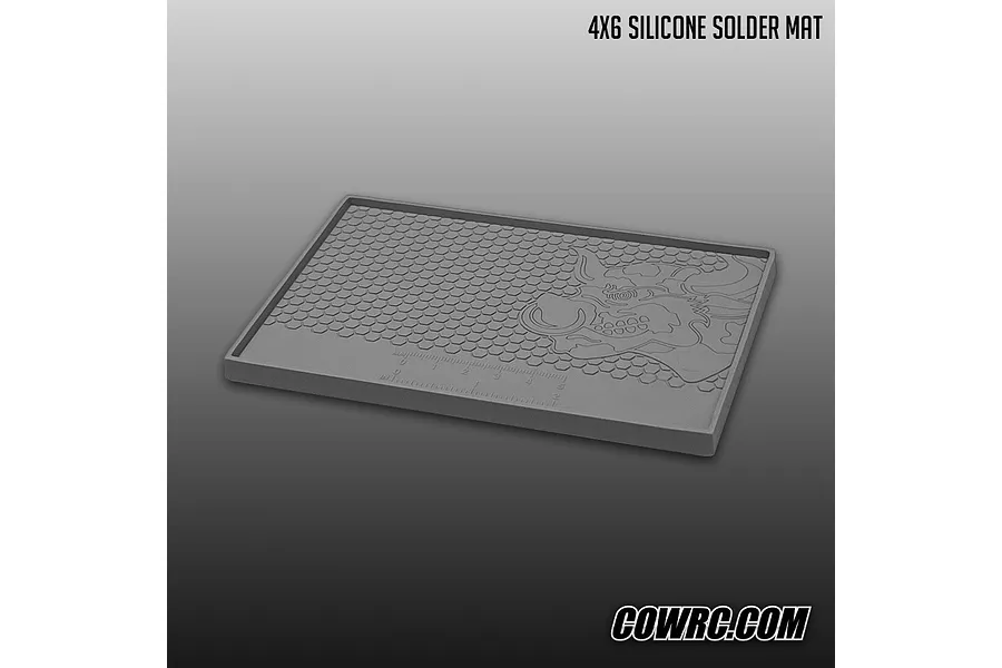 A grey CowRC 4x6 inch silicone solder mat featuring a honeycomb pattern, built-in ruler, and bull logo against a gradient background.