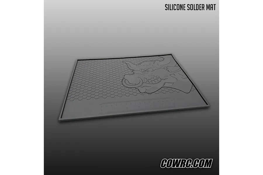 CowRC dark grey silicone solder mat featuring a bull logo, honeycomb texture, and a built-in ruler on a gradient background.