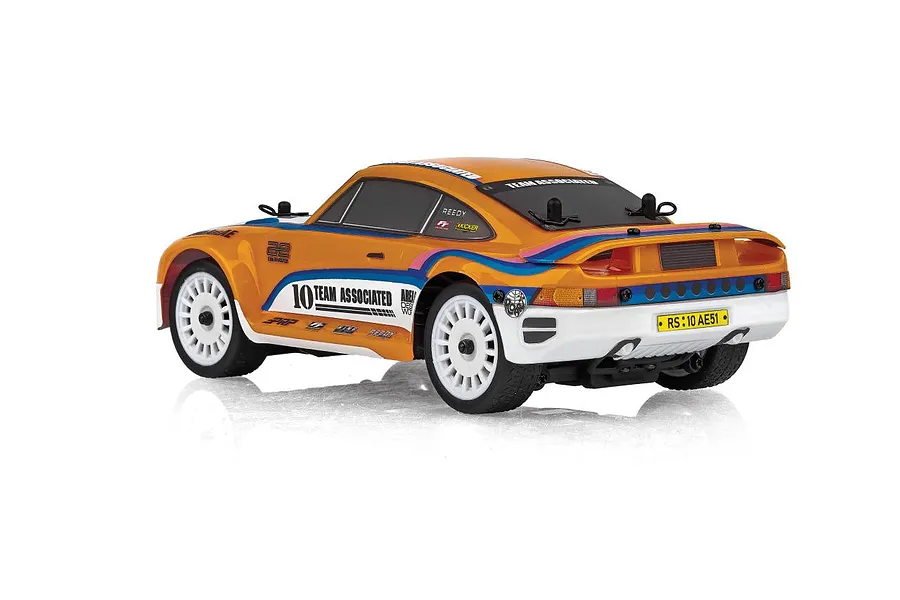 Rear-three-quarter studio view of the Team Associated RC24 Zoom RC rally car featuring orange bodywork, white multi-spoke wheels, and sponsor decals.