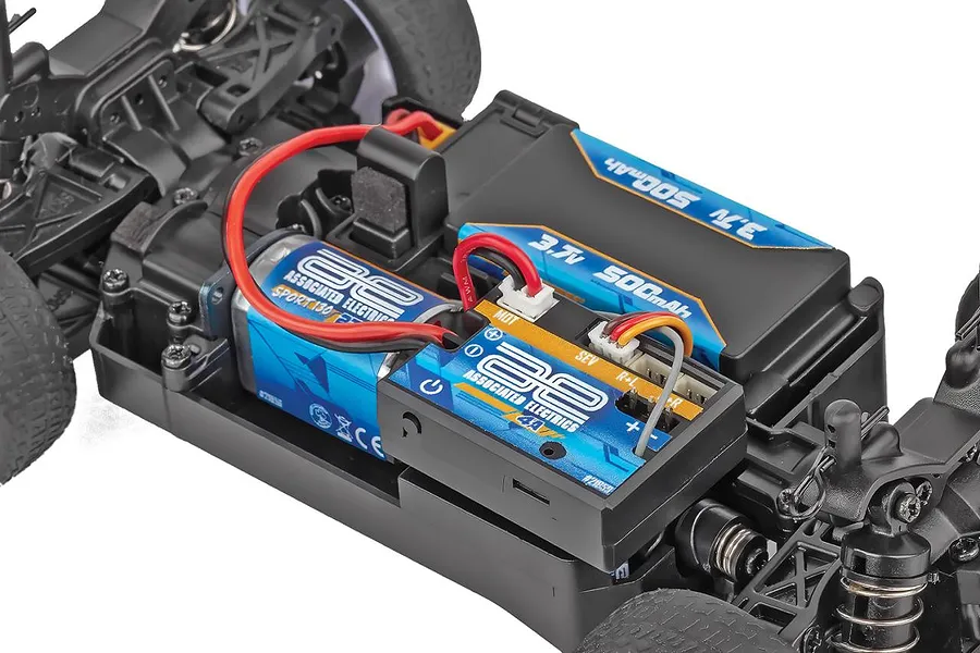 Close-up studio view of the chassis interior of a Team Associated RC24 Zoom showing the motor, receiver and battery installed.