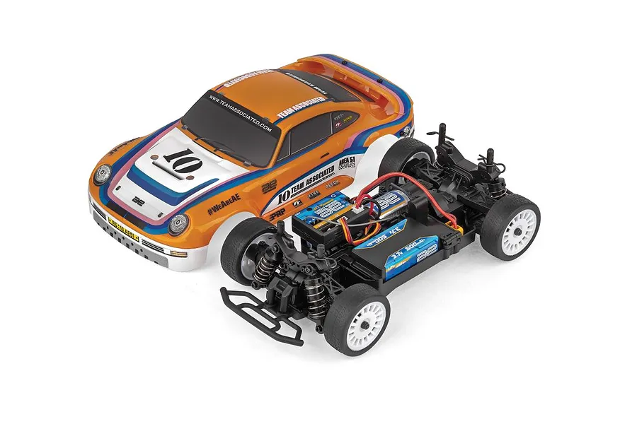 Team Associated 1/24 scale RC rally car shown with its orange and white race-liveried body shell removed from the plastic chassis.